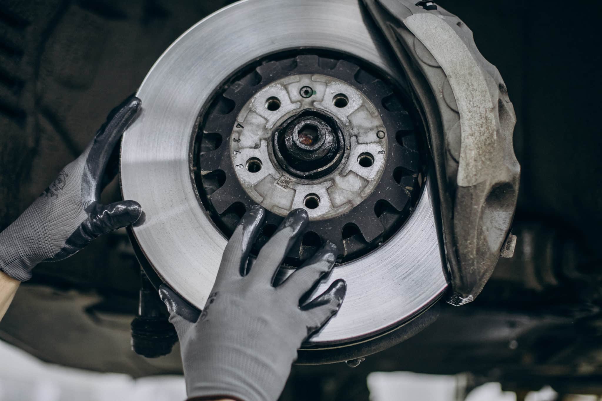 mechanic changing brake discs car service scaled - Groupe Alsoweb